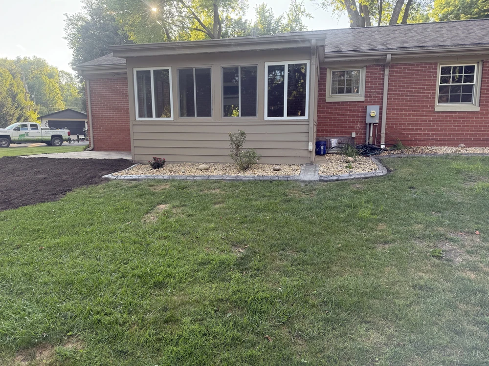 Backyard lawn maintenance after winter thaw, showing soil repair and reseeding to address spongy muddy areas near the home.