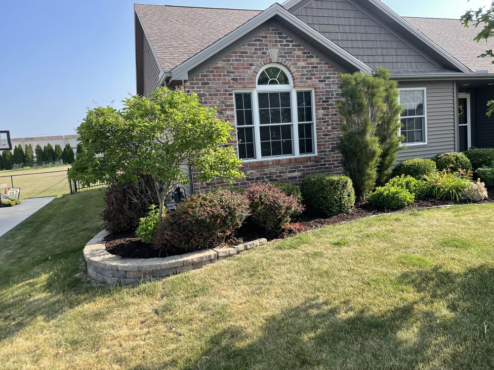 Front yard landscaping refreshed with trimmed shrubs and dark mulch for spring curb appeal.