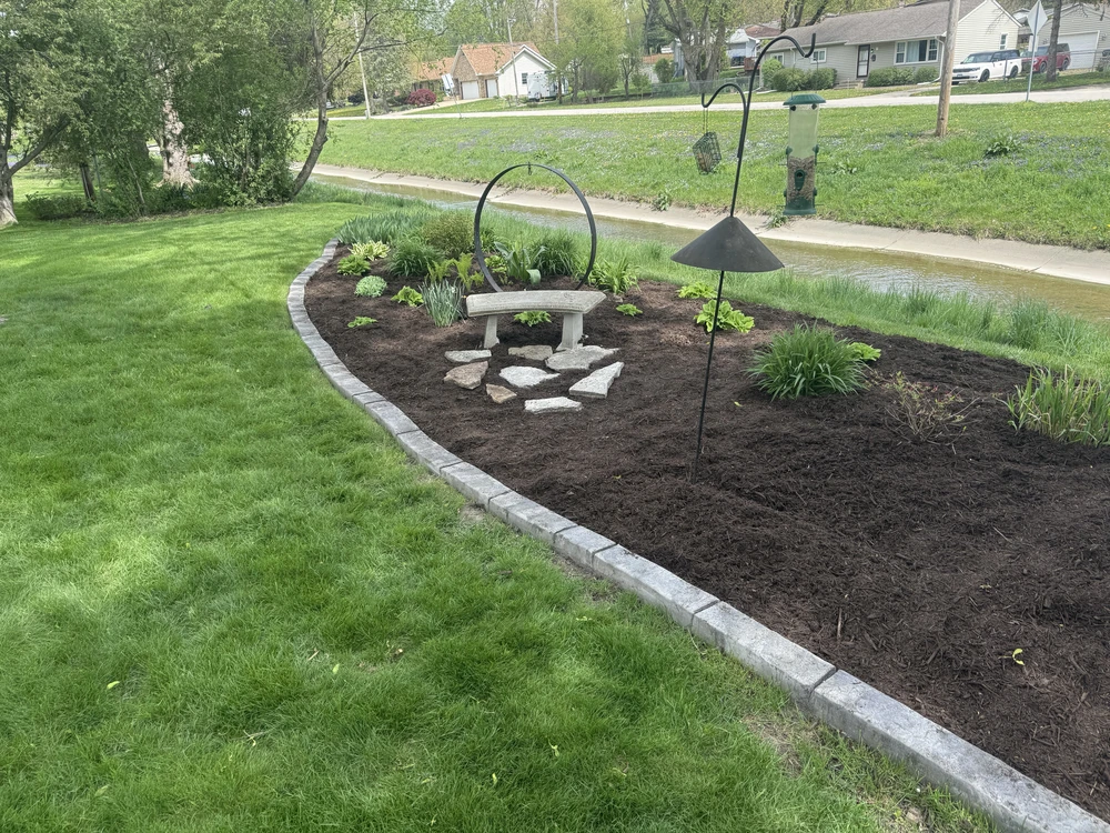 Gray landscape curbing outlines a mulched garden bed and holds its shape better than edging.